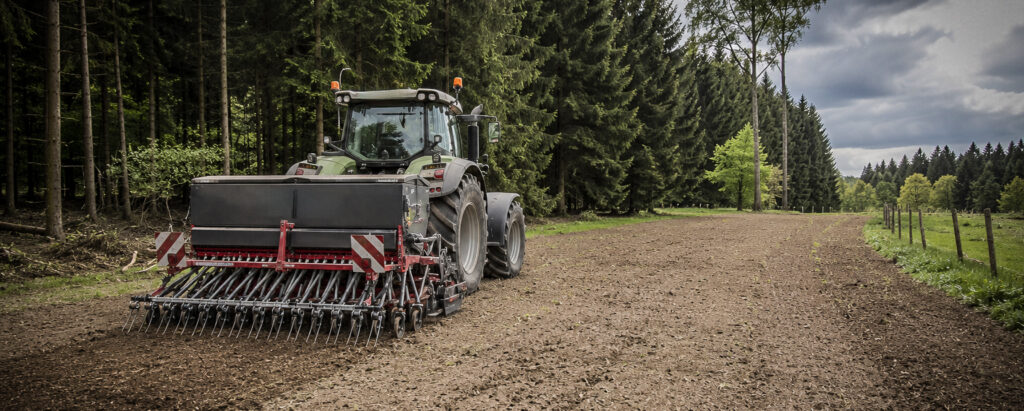 Traktor bei der Bodenbearbeitung und Ansaat einer Grünfläche.